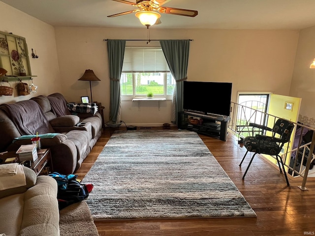 living room featuring baseboards, a ceiling fan, and wood finished floors