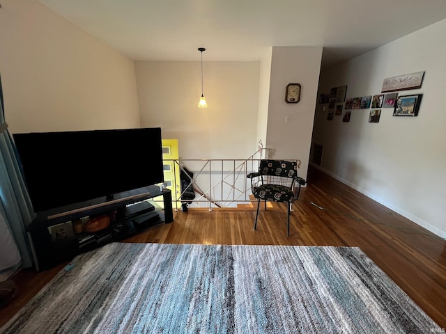 sitting room featuring baseboards, an upstairs landing, and wood finished floors