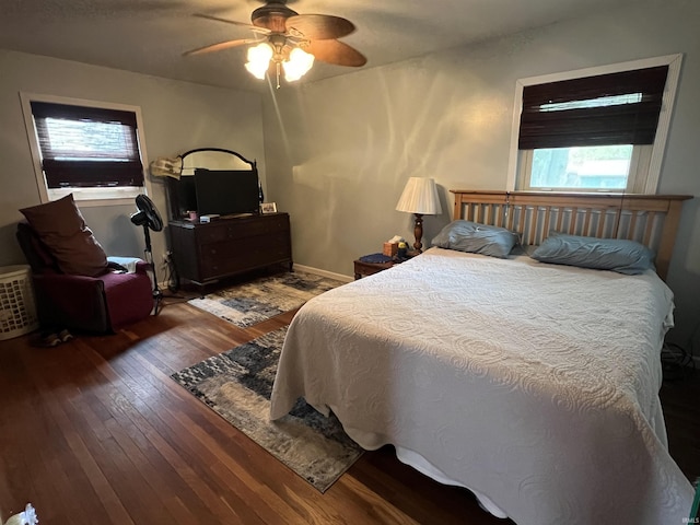 bedroom with ceiling fan, wood-type flooring, baseboards, and multiple windows