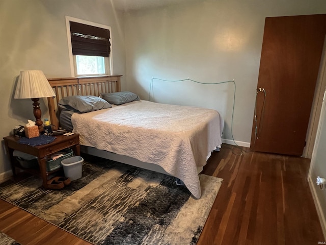 bedroom with dark wood finished floors and baseboards