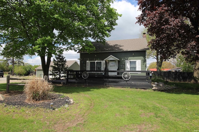 view of front of property featuring a deck, a chimney, fence, and a front yard
