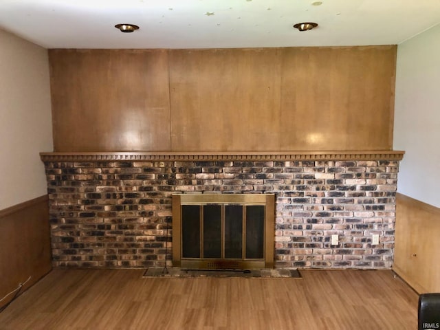 interior details featuring a wainscoted wall and wood finished floors