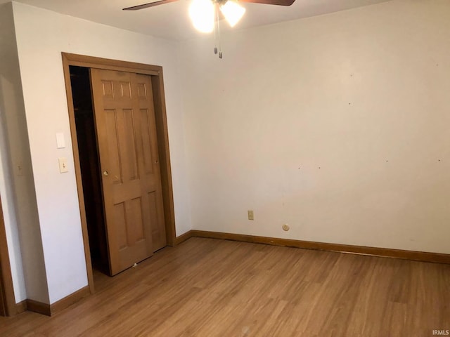 unfurnished bedroom featuring a closet, baseboards, a ceiling fan, and light wood-style floors