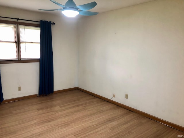 empty room featuring baseboards, light wood finished floors, and ceiling fan