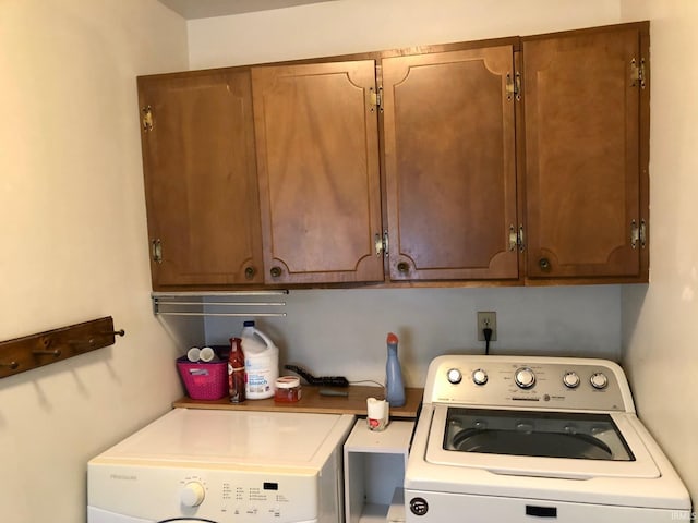 laundry room with washer and clothes dryer and cabinet space
