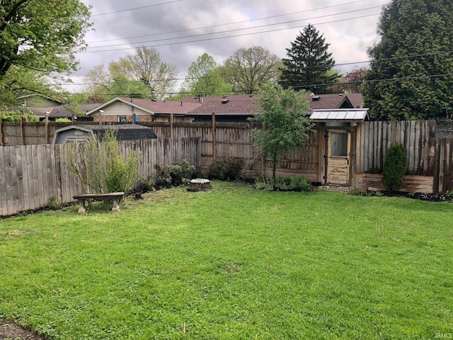 view of yard featuring a fenced backyard and an outbuilding