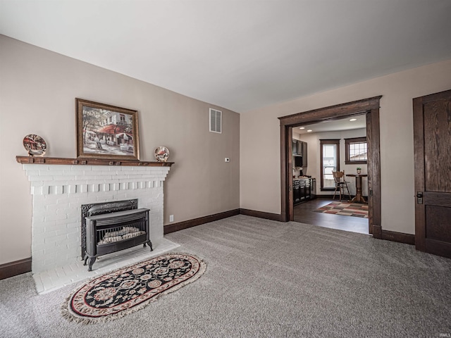 108 S Church St, Owensville, IN 47665 - living area with visible vents, baseboards, a brick fireplace, and carpet floors