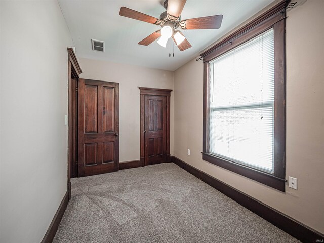 108 S Church St, Owensville, IN 47665 - unfurnished bedroom featuring visible vents, baseboards, ceiling fan, and light carpet