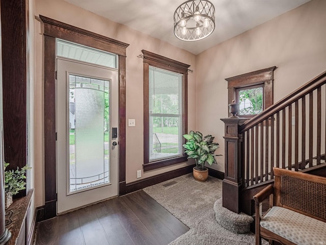 108 S Church St, Owensville, IN 47665 - foyer with baseboards, an inviting chandelier, visible vents, stairs, and dark wood-type flooring