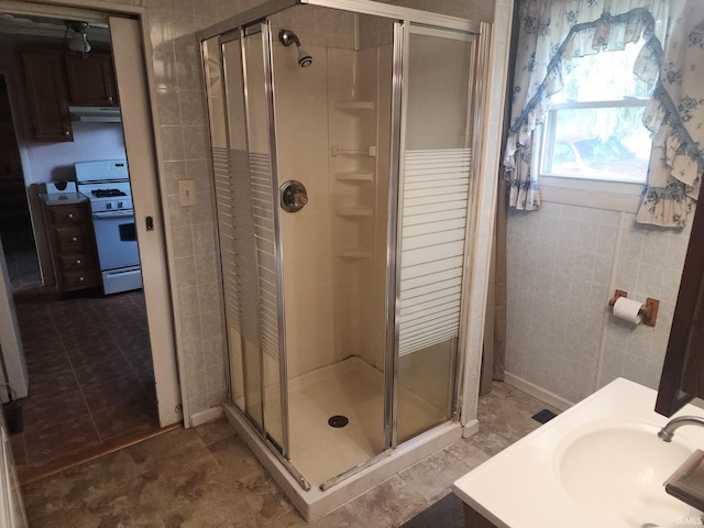 full bath featuring a sink, tile walls, and a stall shower