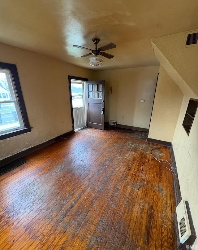 unfurnished room with a ceiling fan, wood-type flooring, and visible vents
