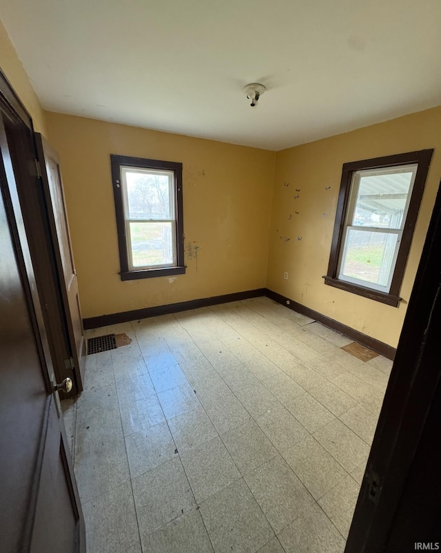 unfurnished bedroom with baseboards and multiple windows