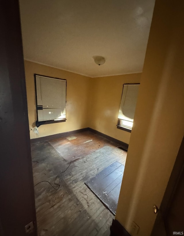 unfurnished room with baseboards and hardwood / wood-style floors