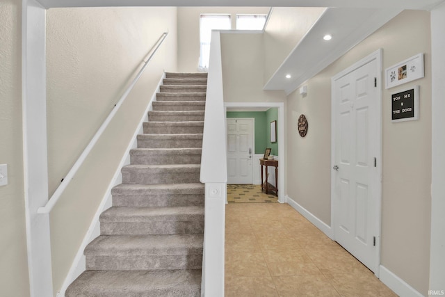 stairway featuring baseboards, tile patterned flooring, and recessed lighting