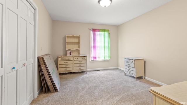 carpeted bedroom featuring baseboards, a closet, and visible vents