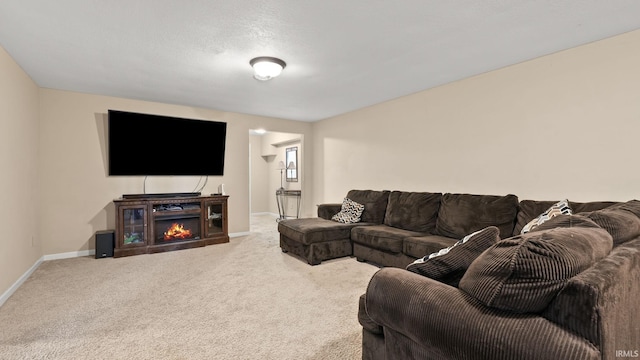 living room featuring carpet flooring, baseboards, and a glass covered fireplace