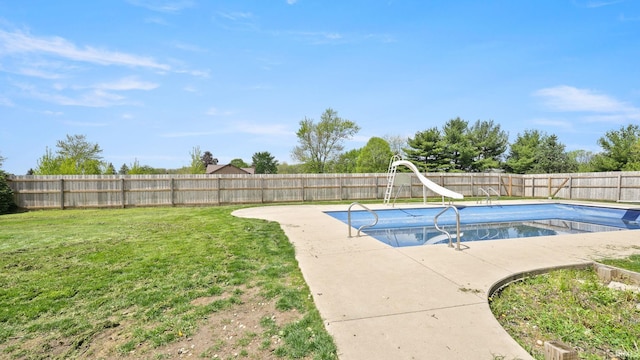 view of swimming pool with a lawn, a water slide, a fenced in pool, and a fenced backyard