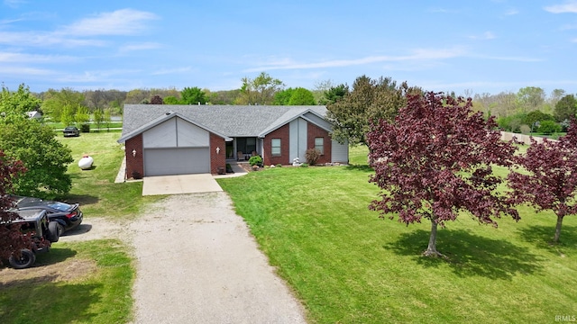 ranch-style house with an attached garage, a shingled roof, a front yard, brick siding, and driveway