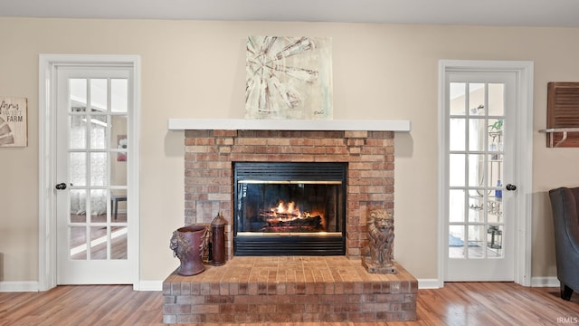 interior details with a brick fireplace, baseboards, and wood finished floors