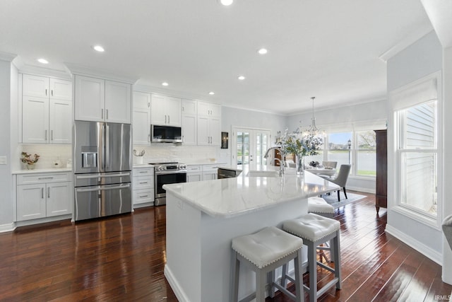 kitchen with stainless steel appliances, tasteful backsplash, dark wood finished floors, and a sink