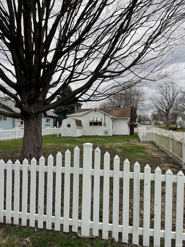 exterior space with an outdoor structure, a front yard, a fenced backyard, and a shed