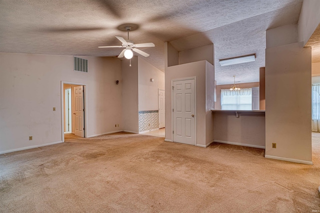 unfurnished living room with carpet floors, a textured ceiling, visible vents, baseboards, and vaulted ceiling