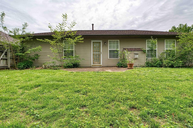 rear view of house featuring fence and a lawn