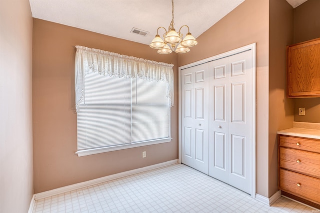 unfurnished bedroom with an inviting chandelier, visible vents, baseboards, and a closet
