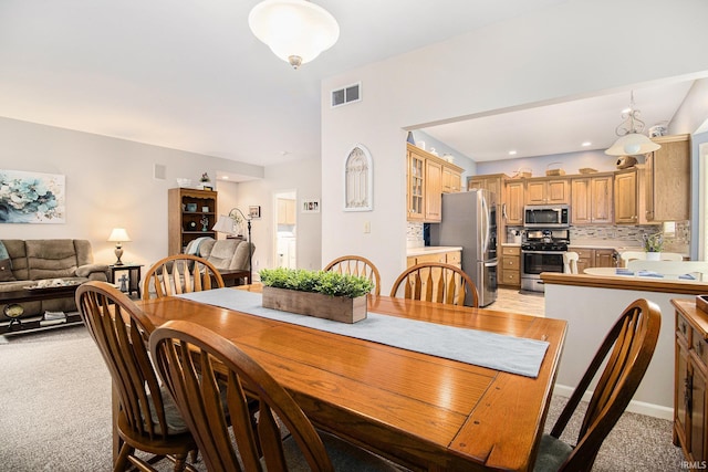 dining room featuring light colored carpet, baseboards, and visible vents