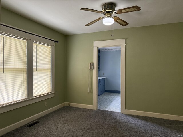 1406 E Hillside Dr, Bloomington, IN 47401 - empty room featuring dark carpet, visible vents, baseboards, and ceiling fan