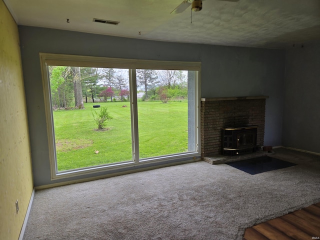 unfurnished living room featuring carpet flooring, visible vents, baseboards, and ceiling fan