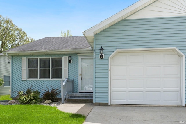 ranch-style home featuring driveway, a shingled roof, and an attached garage