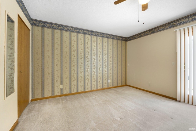 spare room featuring carpet floors and a ceiling fan