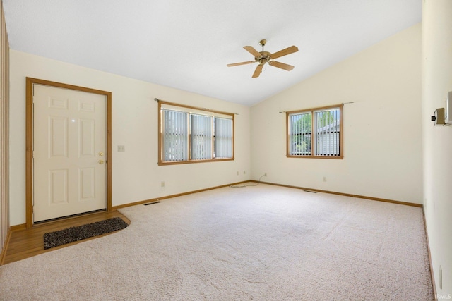 entryway with carpet, baseboards, visible vents, ceiling fan, and vaulted ceiling