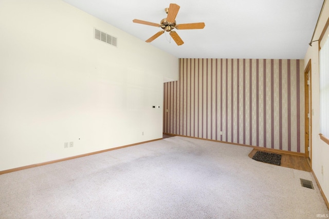 spare room featuring vaulted ceiling, ceiling fan, carpet flooring, and visible vents