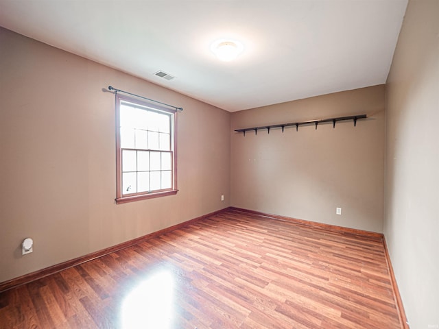 empty room featuring light wood-style flooring, baseboards, and visible vents