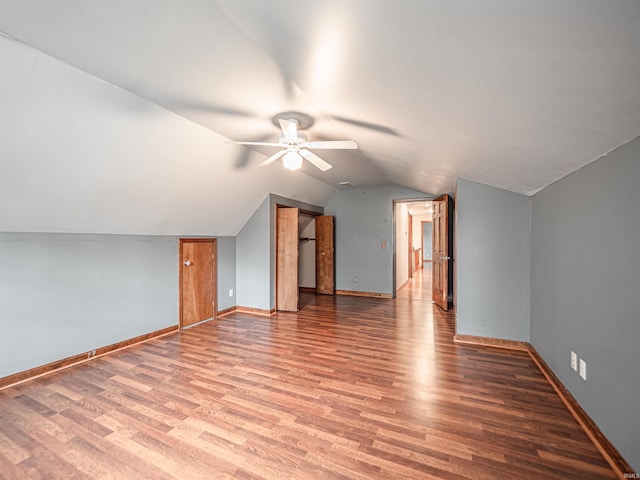 additional living space featuring wood finished floors, baseboards, ceiling fan, and lofted ceiling