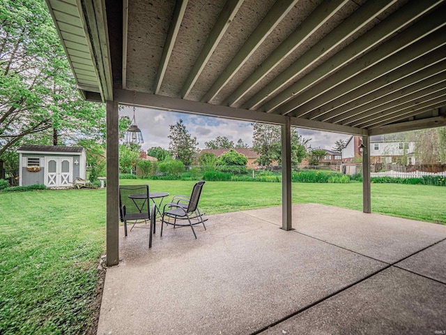 view of patio / terrace featuring an outdoor structure, fence, and a storage unit