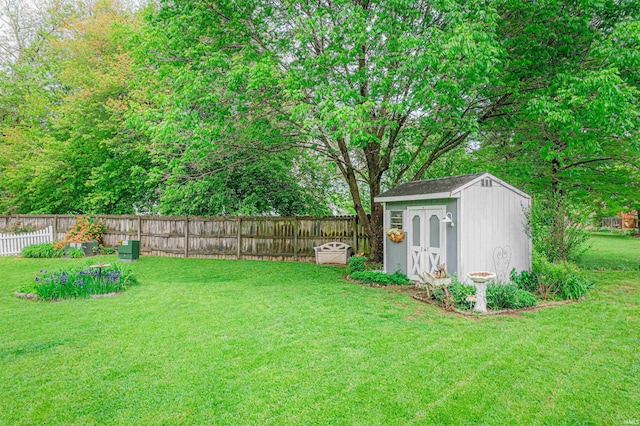 view of yard featuring a fenced backyard, an outdoor structure, and a shed