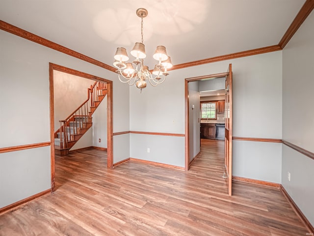 unfurnished room with baseboards, stairway, light wood finished floors, and an inviting chandelier