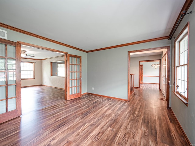 unfurnished room featuring baseboards, visible vents, crown molding, and wood finished floors