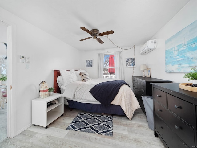 bedroom with light wood-style flooring, a ceiling fan, and an AC wall unit