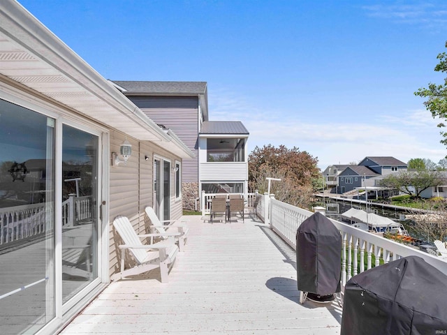 wooden deck with outdoor dining space and a grill