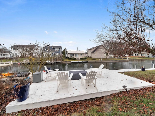 view of dock with a deck with water view and a residential view