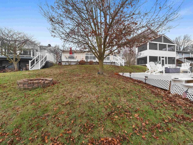 view of yard featuring an outdoor fire pit, a sunroom, and stairs