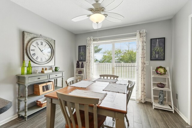 dining space with a ceiling fan, baseboards, and wood finished floors