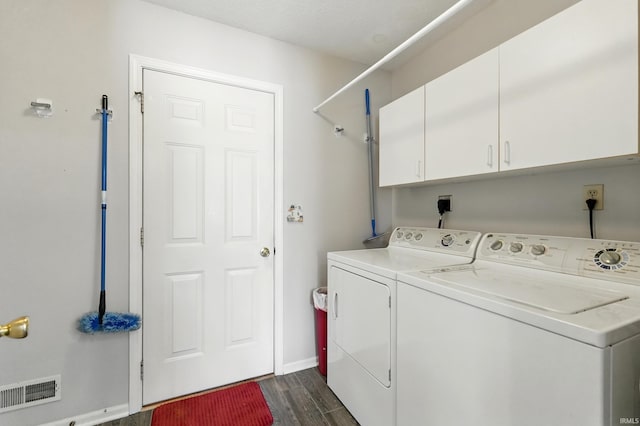 laundry room with cabinet space, dark wood-type flooring, visible vents, washing machine and clothes dryer, and baseboards