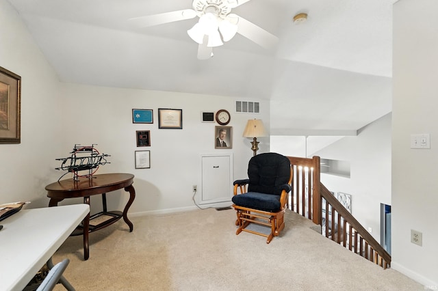 living area featuring an upstairs landing, visible vents, carpet floors, a ceiling fan, and baseboards