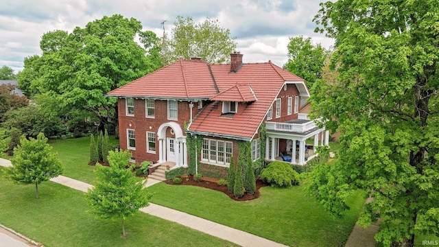 104 W Main St, Worthington, IN 47471 - view of front of house with a front lawn, a tiled roof, a chimney, and a balcony