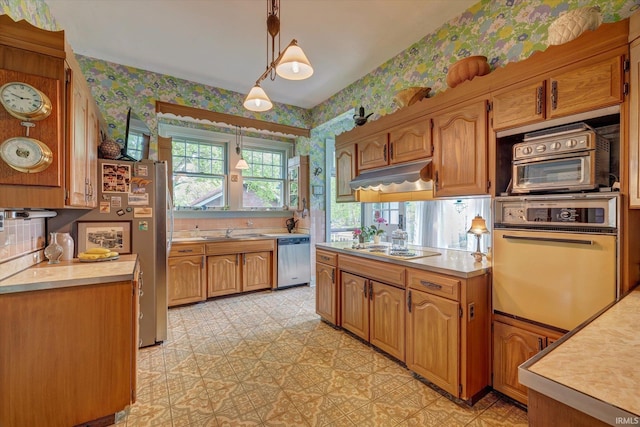 104 W Main St, Worthington, IN 47471 - kitchen with under cabinet range hood, wallpapered walls, appliances with stainless steel finishes, and light countertops